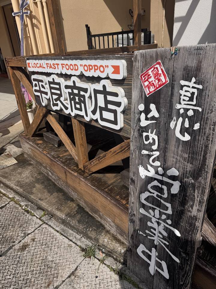 入口に置かれた「平良商店」の木の看板と黒い立て看板